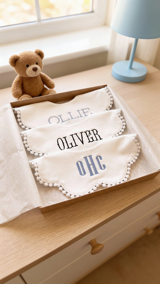 Close-up of embroidered monogram detail on baby boy bib