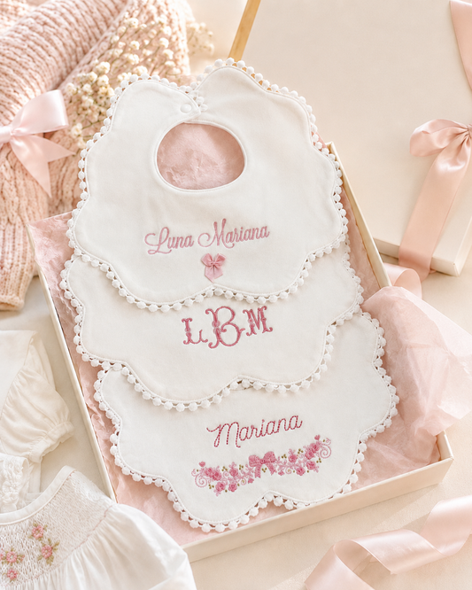 Close-up of embroidered monogram detail on baby girl bib