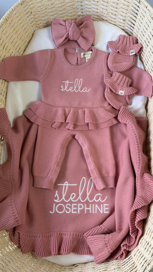 Personalized Dusty Mauve Ballerina long romper set displayed with matching oversized bow, ruffle booties and knit blanket.