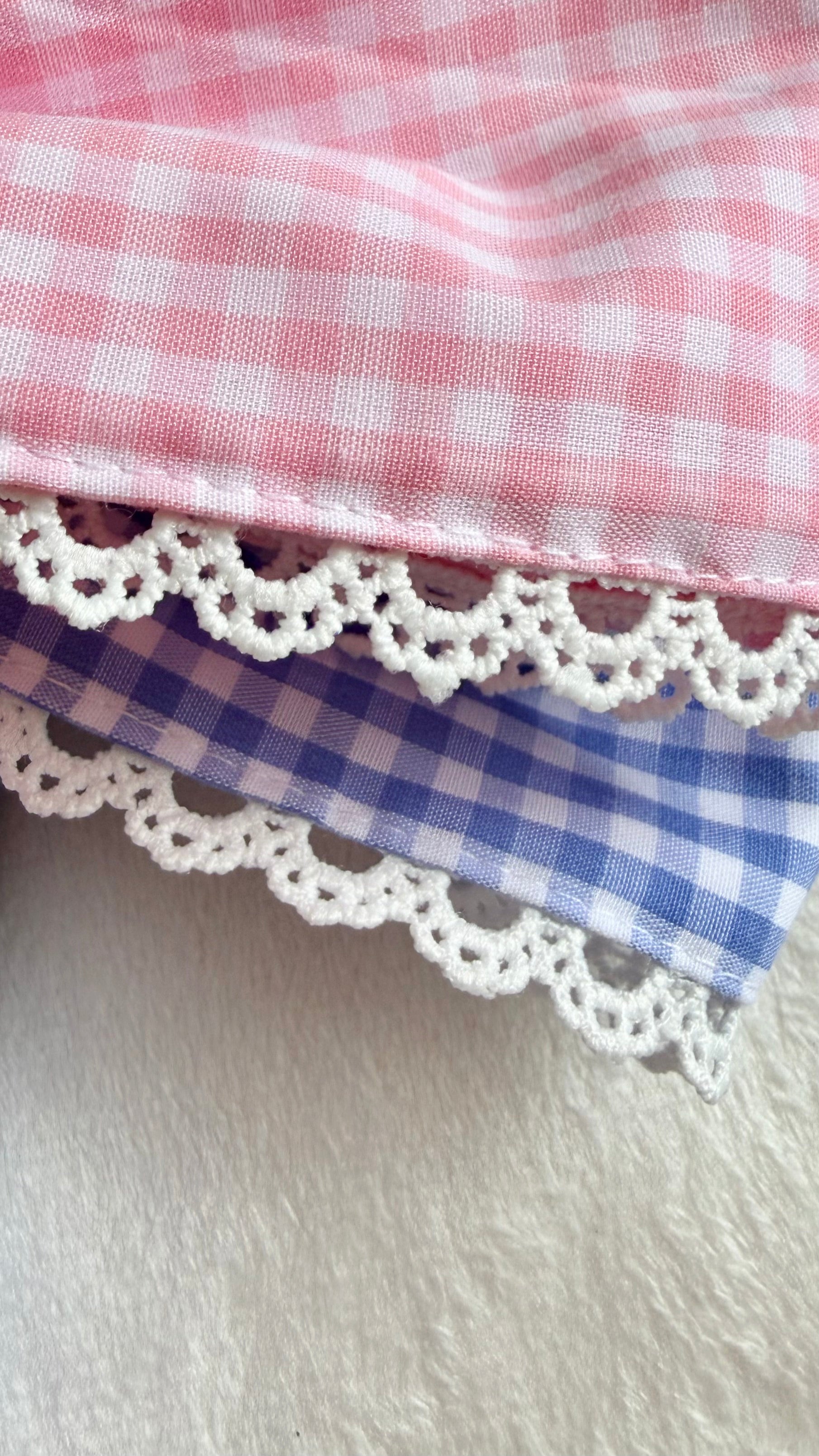 Close-up of lace gingham applique monogram embroidery on newborn bow sash