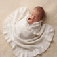 Newborn swaddled in personalized ballerina knit baby blanket with ruffled trim detail