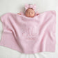 Newborn baby wrapped in personalized classic knit blanket with embroidered name in soft cotton