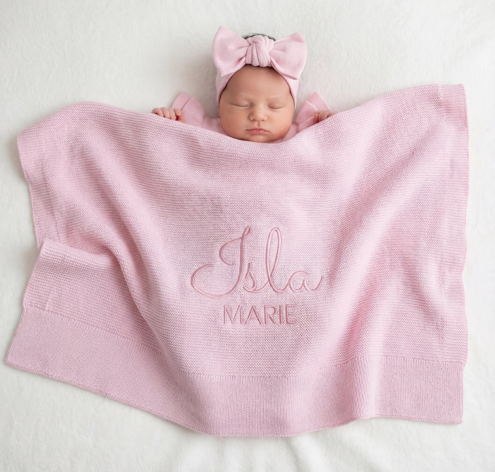 Newborn baby wrapped in personalized classic knit blanket with embroidered name in soft cotton