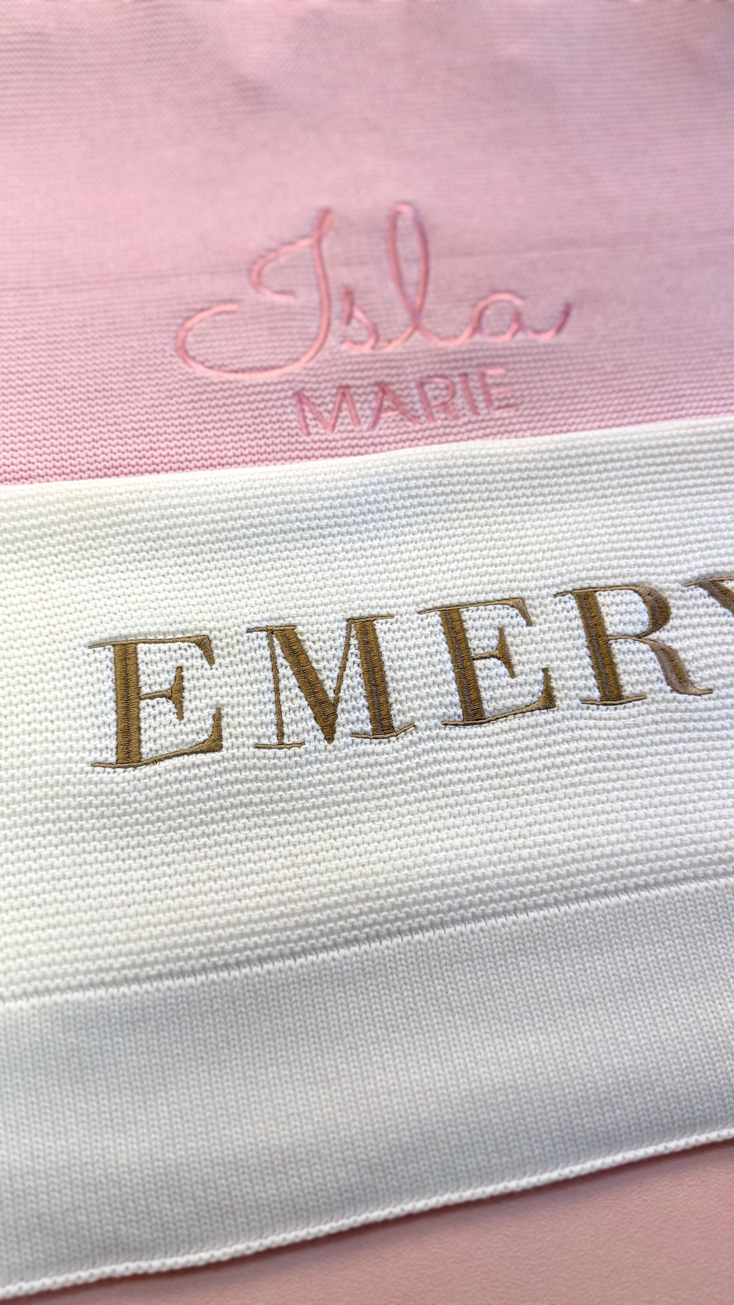 Close-up of personalized baby blanket embroidery showing script and block name styles on knit fabric