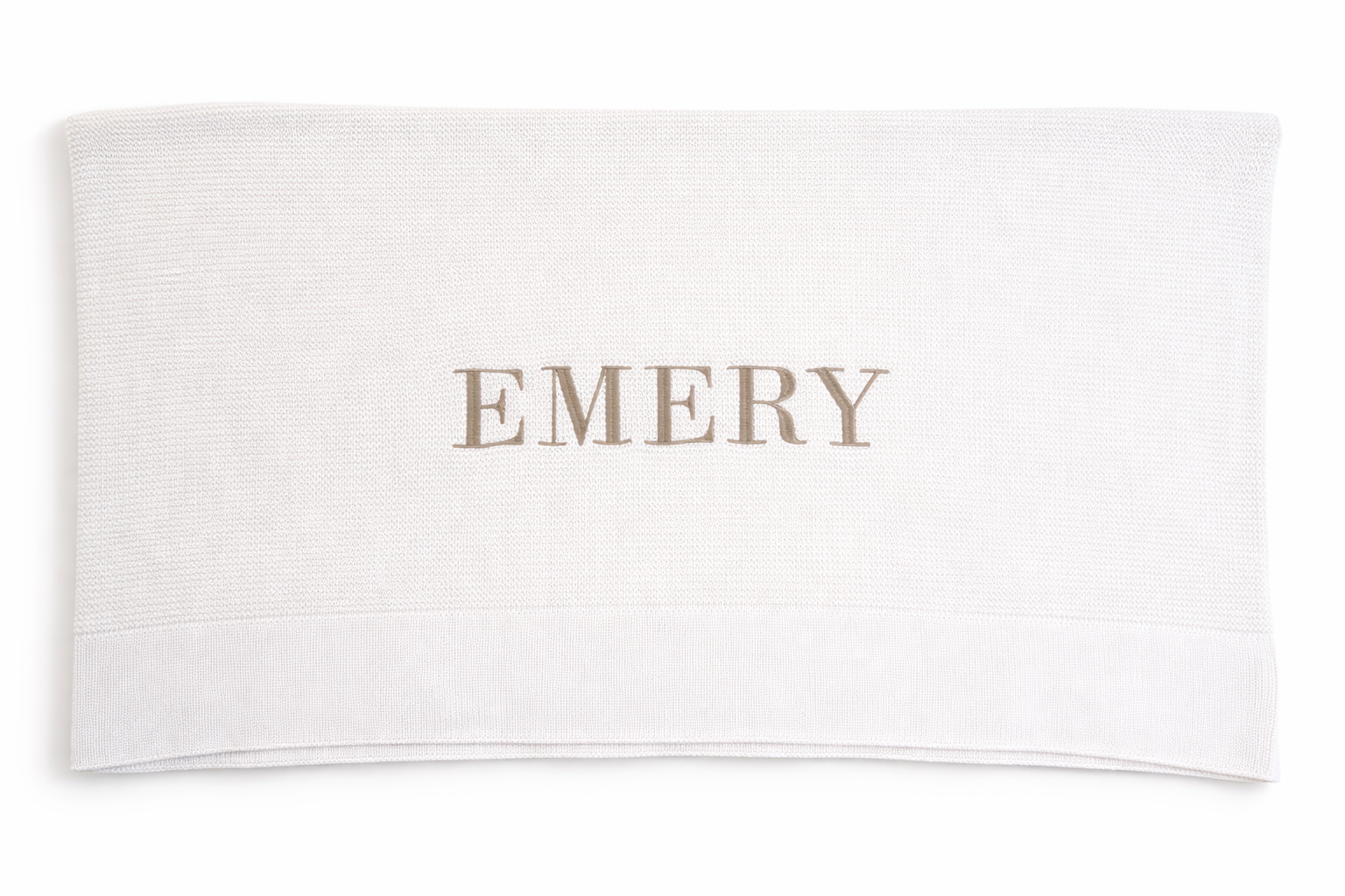 Personalized baby blanket with embroidered name styled with ribbon detail in soft ivory knit