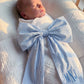 Newborn baby wearing personalized blue striped name sash with oversized bow and embroidered monogram, soft cotton hospital announcement outfit keepsake gift for baby boy