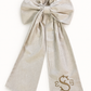 Personalized striped newborn sash with oversized bow and embroidered monogram shown in flat lay on white background