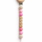 Personalized baby pacifier clip with Lola name beads in soft pink tones, a practical and meaningful newborn gift