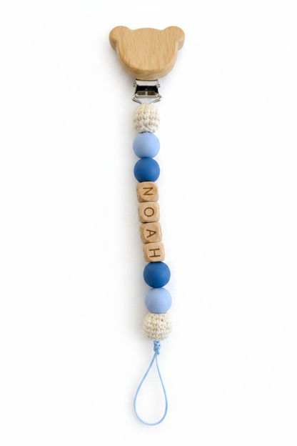 Personalized baby pacifier clip with Noah name beads in soft blue tones, a practical and thoughtful newborn gift