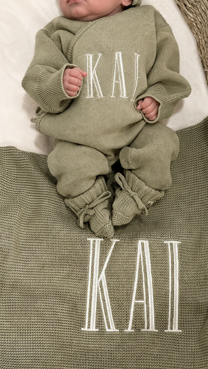 Newborn wearing a personalized Soft Sage Kimono Romper Set with matching bear-ear hat and blanket