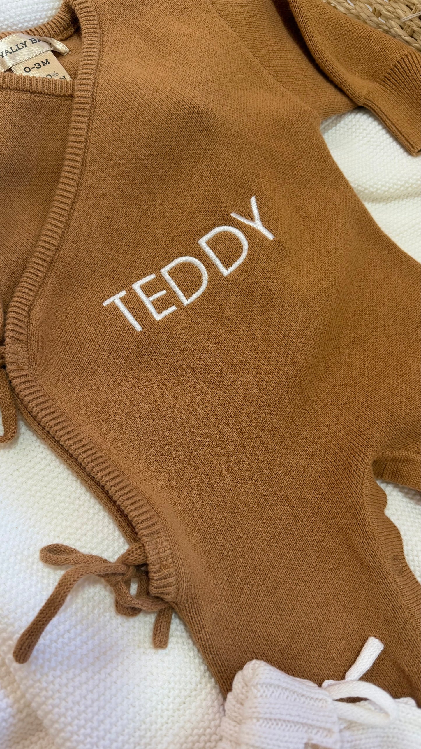 Close-up of personalized name embroidery on a Teddy Brown newborn knit romper