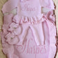 Personalized petal pink Ballerina long romper set arranged with a matching bow, ruffle booties and ruffle knit blanket.