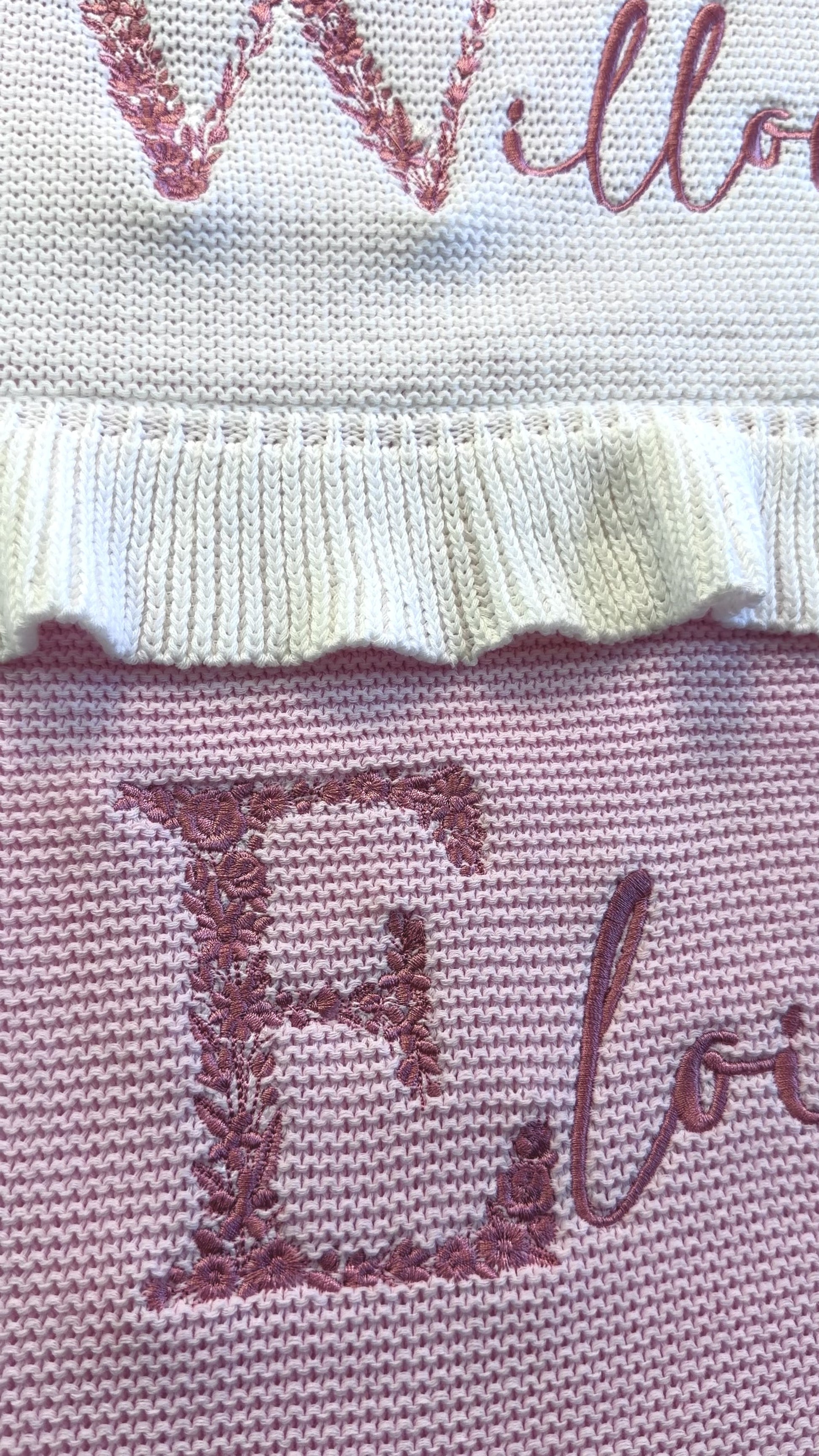 Video of personalized floral initial baby blanket with embroidered name and soft ruffled trim in knit cotton