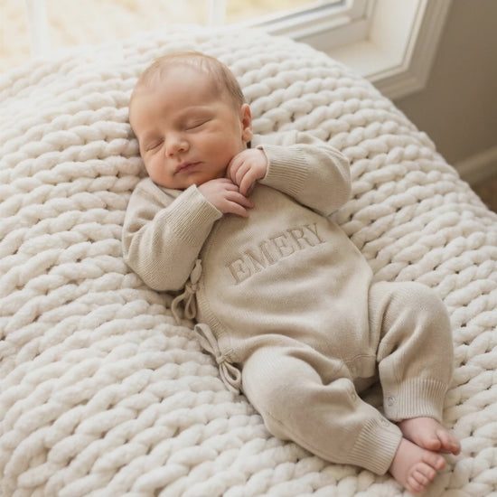 Newborn baby wearing classic knit wrap romper in soft khaki with personalized embroidery