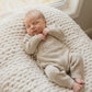 Newborn baby wearing classic knit wrap romper in soft khaki with personalized embroidery