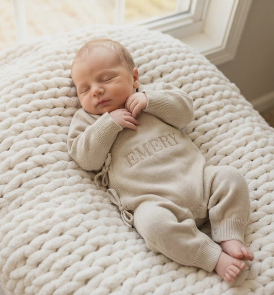 Newborn baby wearing classic knit wrap romper in soft khaki with personalized embroidery