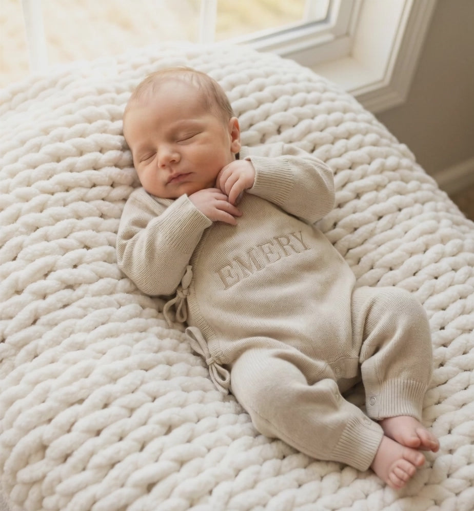 Newborn baby wearing classic knit wrap romper in soft khaki with personalized embroidery
