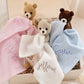 Close-up of handmade Beau Bear and embroidered muslin lovey detail
