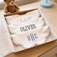 Close-up of embroidered monogram detail on baby boy bib