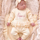 Newborn in a personalized Buttercream Yellow Ballerina long romper embroidered with Poppie and matching bow