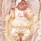 Newborn wearing the personalized Buttercream Yellow Ballerina long romper set with bow and ruffle blanket