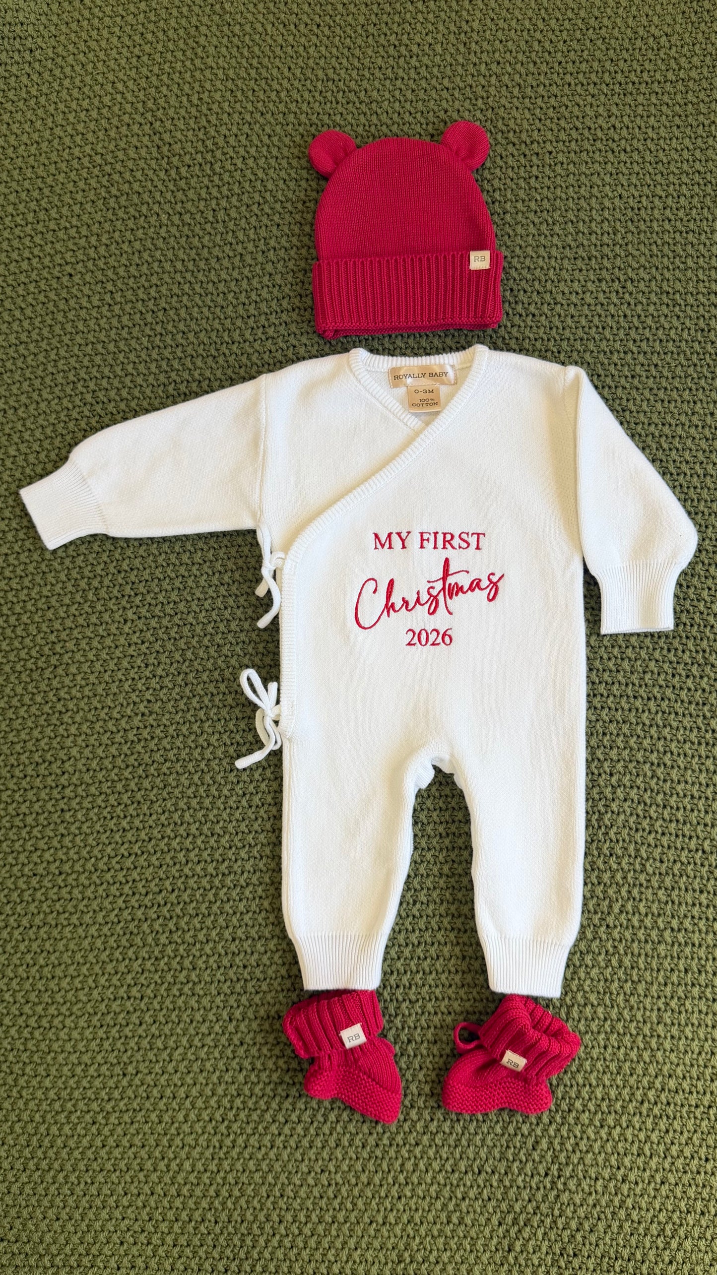 Close-up of My First Christmas embroidery in red thread on a newborn boy Christmas romper