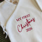 Newborn boy Christmas romper set laid flat with bear-ear hat and knit booties