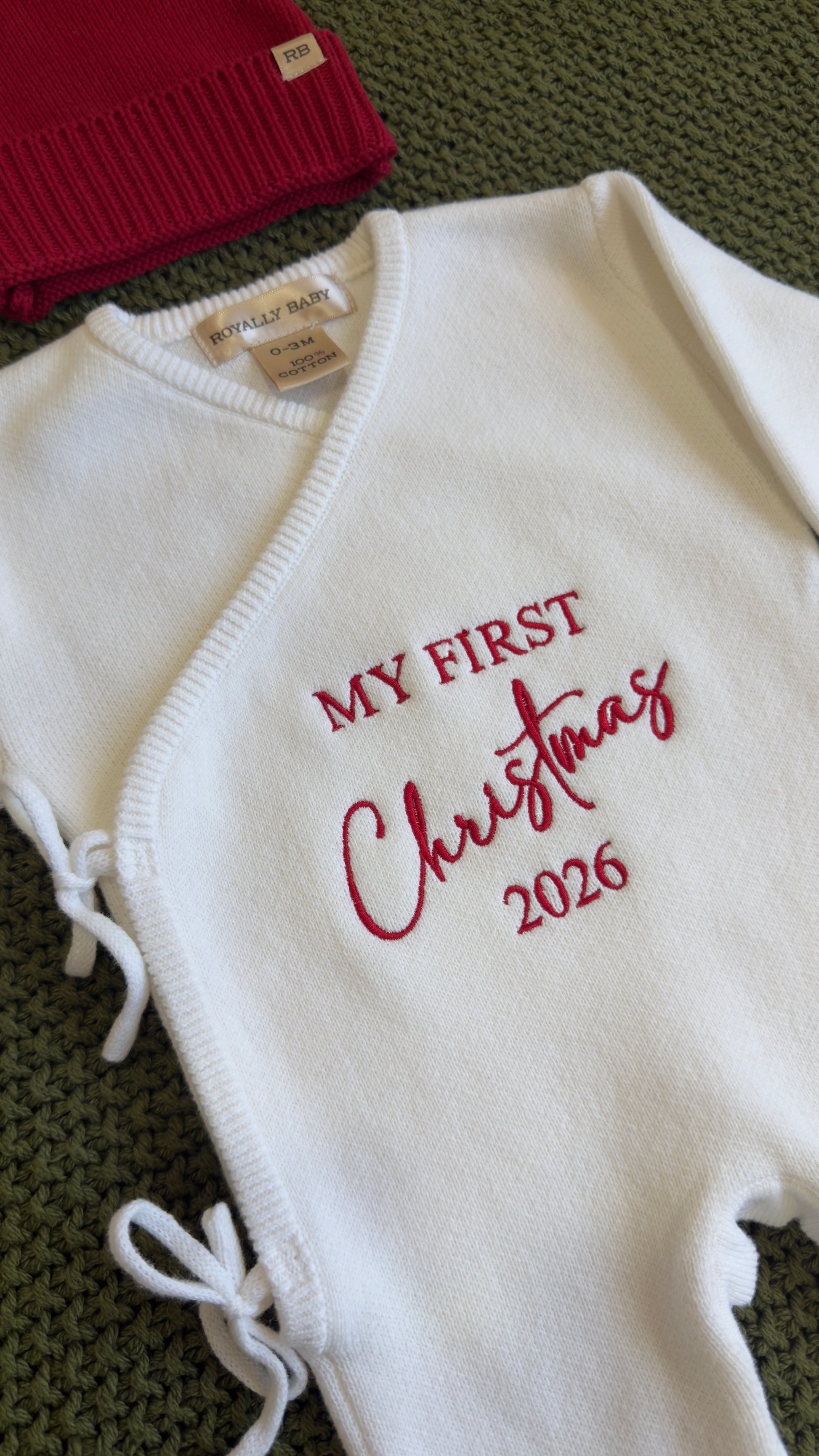Newborn boy Christmas romper set laid flat with bear-ear hat and knit booties