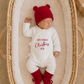 Newborn boy wearing a personalized Christmas romper embroidered My First Christmas with a matching bear-ear hat