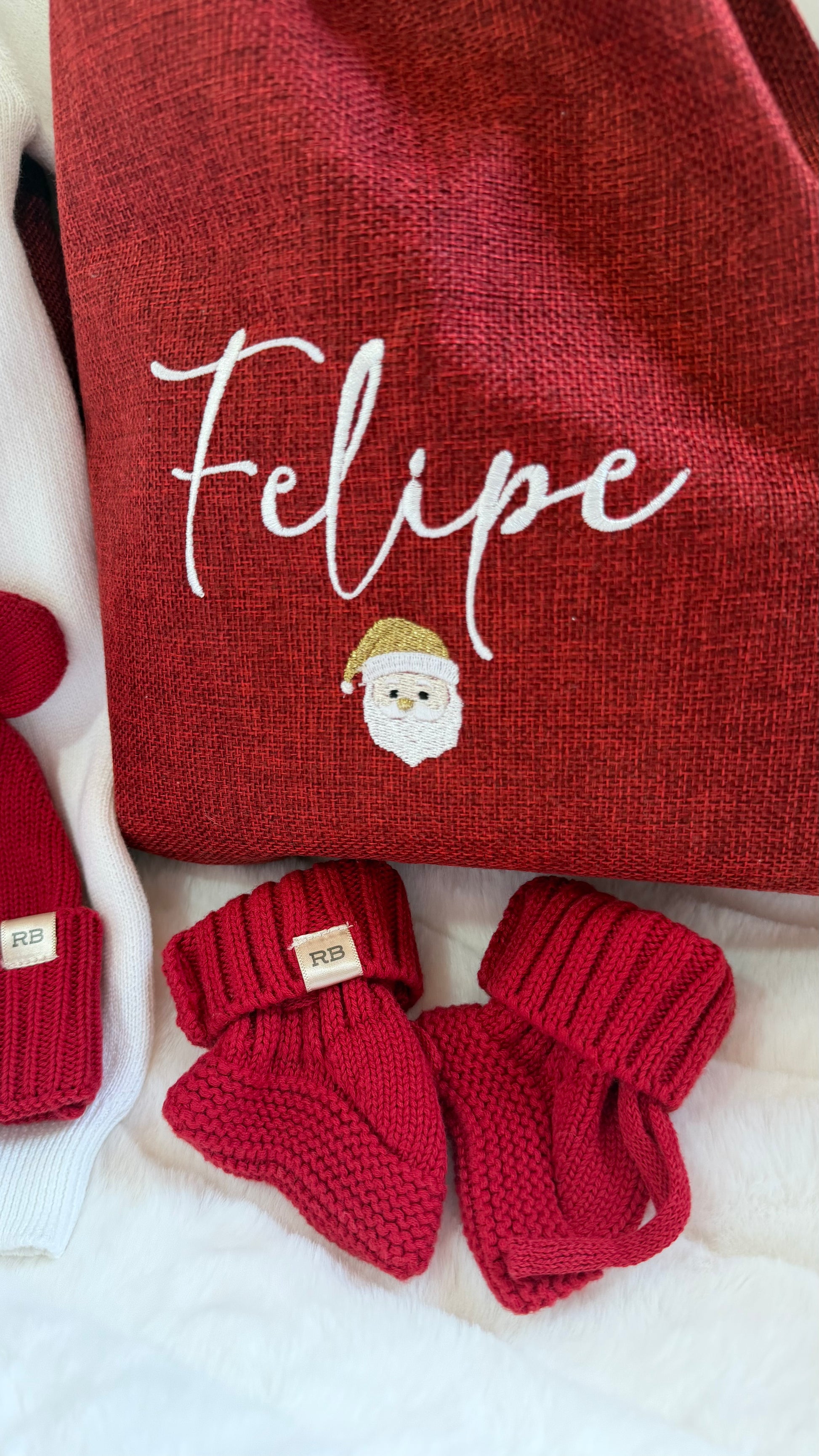 Personalized Christmas gift sack styled with holiday greenery and ornaments