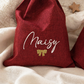Two personalized Christmas gift sacks styled on ivory shearling with holiday decor