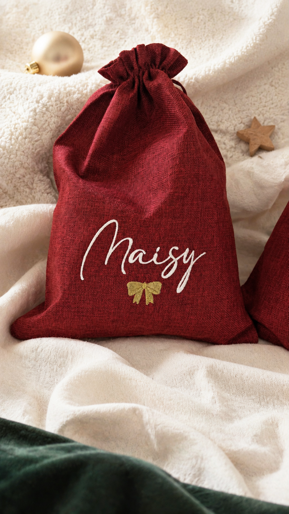 Two personalized Christmas gift sacks styled on ivory shearling with holiday decor
