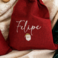 Personalized Santa Claus gift sacks styled on ivory bouclé with Christmas ornaments