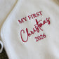 Newborn girl Christmas romper set laid flat with bow and knit booties
