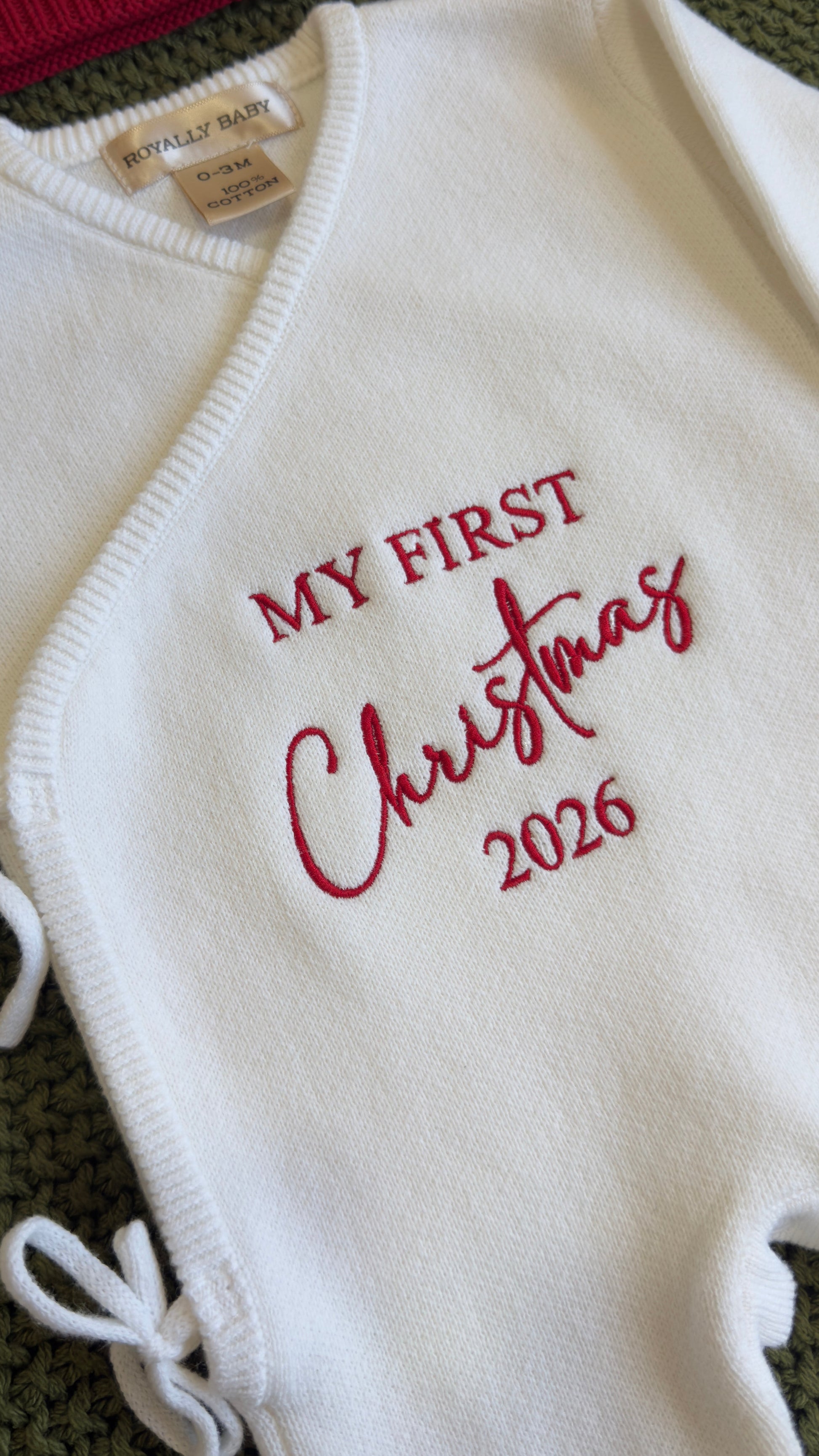 Newborn girl Christmas romper set laid flat with bow and knit booties