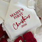 Newborn wearing a personalized Christmas romper with bear-ear hat and booties
