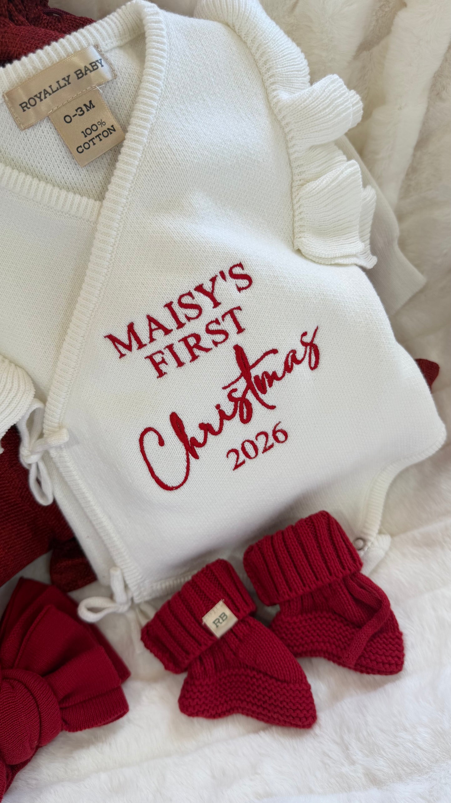 Newborn wearing a personalized Christmas romper with bear-ear hat and booties