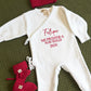 Newborn in a personalized Christmas romper styled for coming home photos
