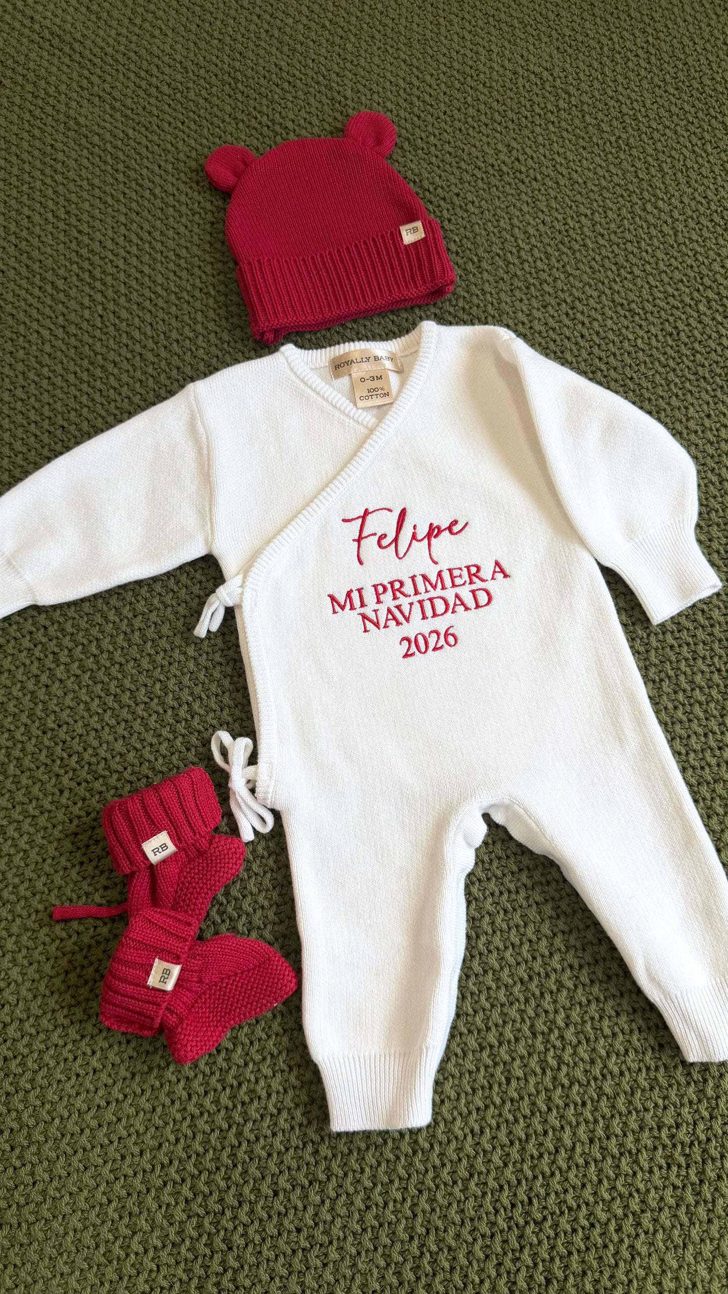 Newborn in a personalized Christmas romper styled for coming home photos