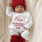 Sleeping newborn in a personalized Christmas romper with holiday knit styling