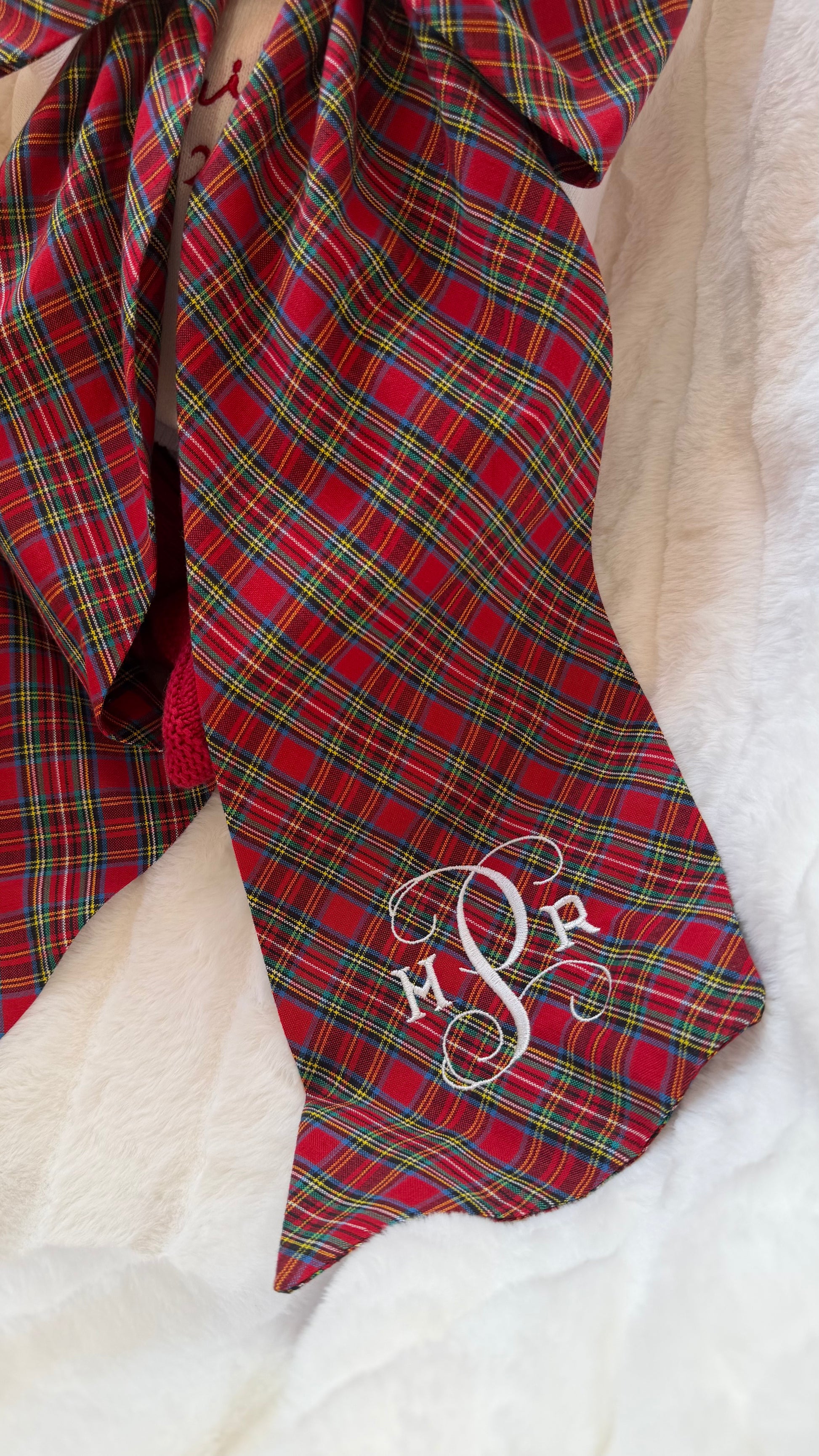 Close-up of monogram embroidery on a newborn Christmas sash