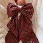 Sleeping newborn wrapped in a personalized plaid tartan Christmas sash with monogram