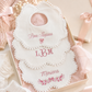 Close-up of embroidered monogram detail on baby girl bib