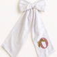 Golden Bows Metallic bow sash flat lay showing shimmering embroidered detail