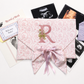 Personalized keepsake envelope styled flat lay with ribbon detail