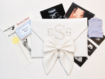 First Moments Keepsake Envelope shown open with hospital bracelet and first photo