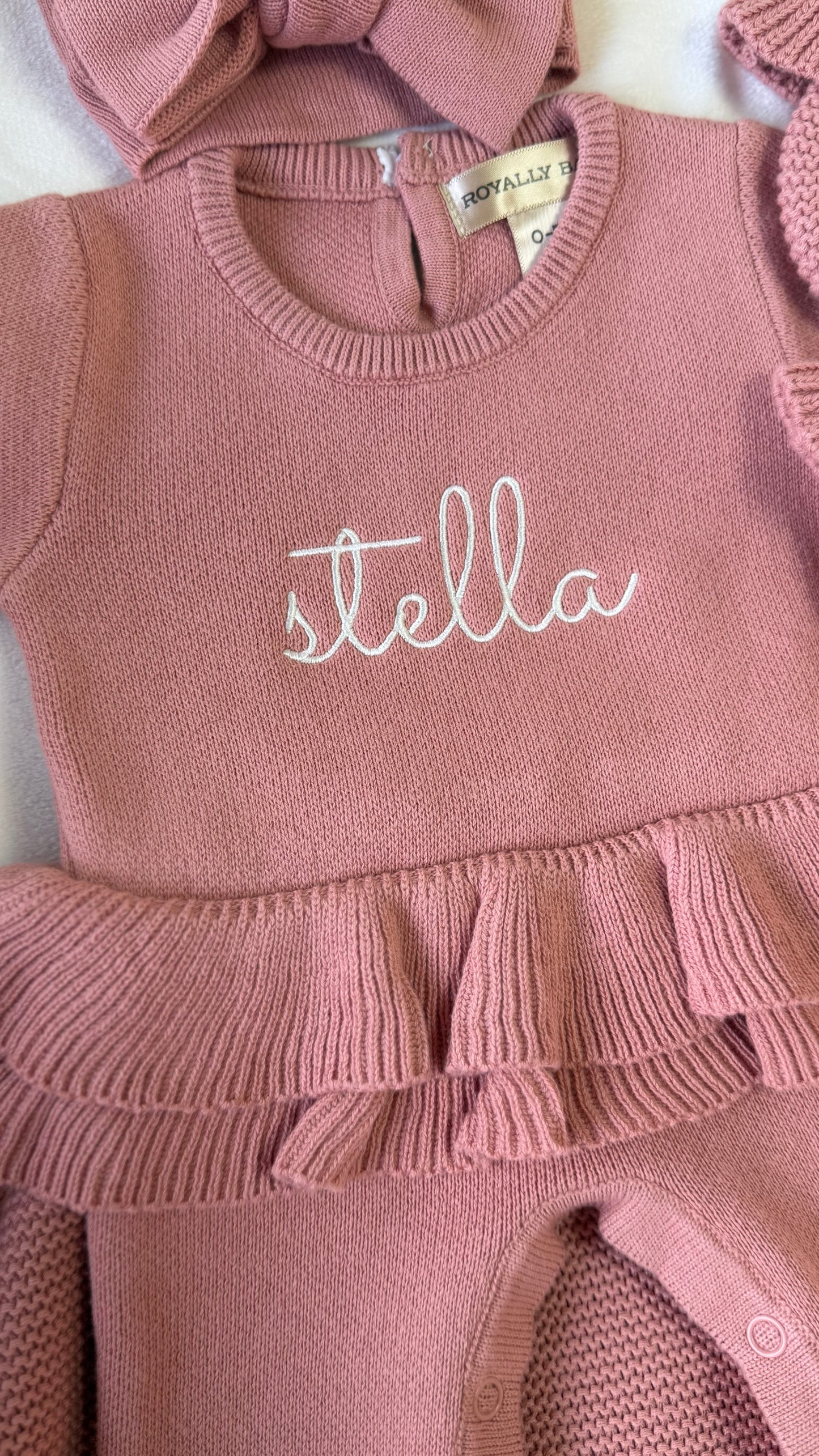 Close-up of Stella name embroidery and layered waist ruffle on the Dusty Mauve Ballerina long newborn romper.