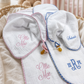 Muslin Pacifier Lovey, Burp Cloth and Blanket 3-Piece Set styled lifestyle shot in pink gingham