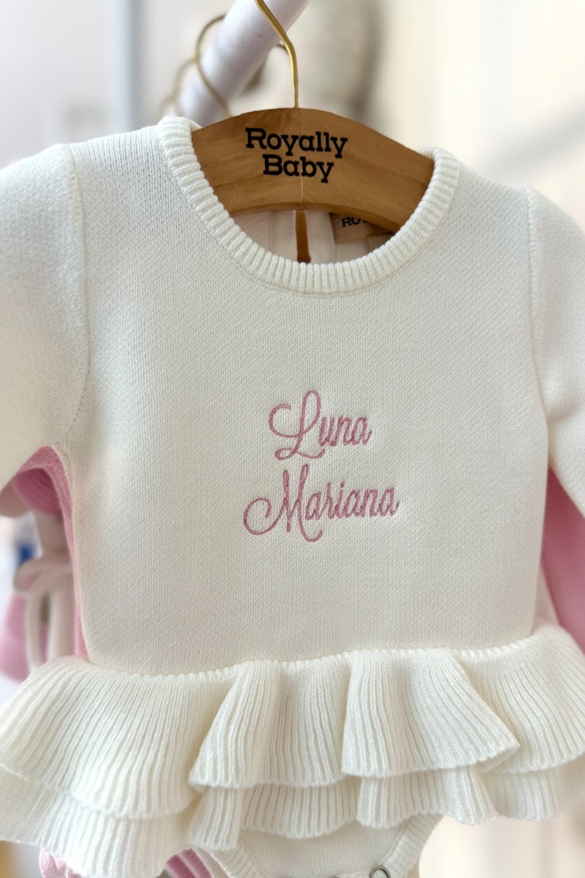 Detailed view of embroidered name on personalized Soft Ivory ballerina baby romper showing soft knit texture and ruffle trim