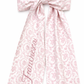 Personalized pink floral newborn name sash bow with embroidered script name detail for baby girl hospital announcement photos and luxury coming home styling.